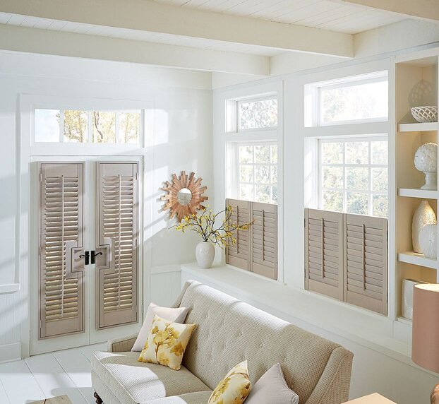 White hinged plantation shutters on French doors, combining functional light control with an elegant, seamless door treatment