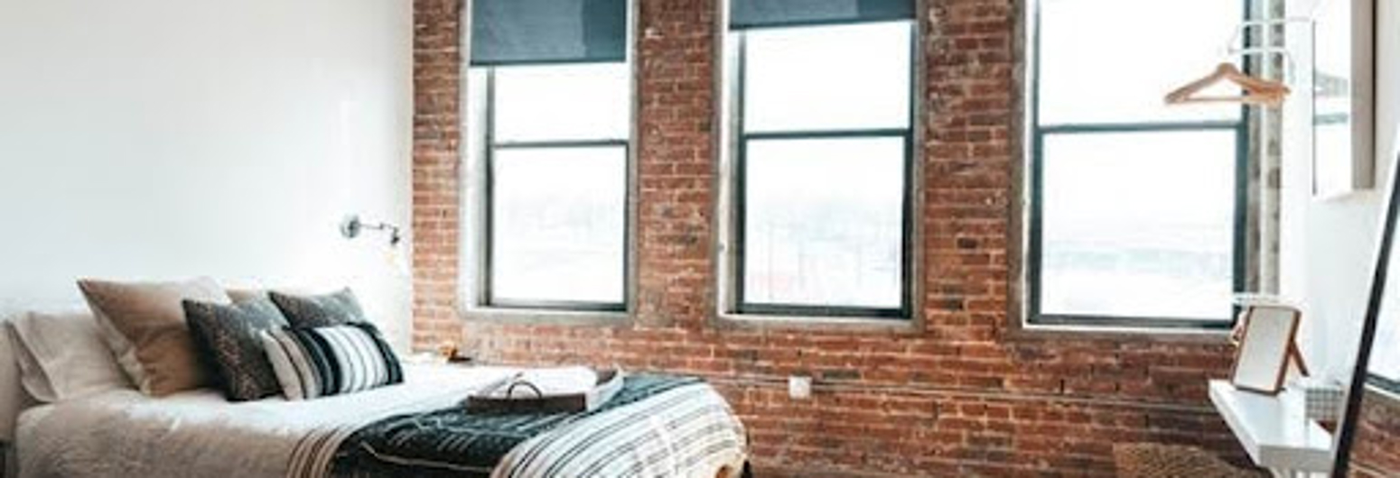 Cozy bedroom studio with brick wall | Gotcha Covered
