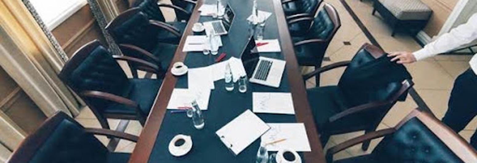 Empty small conference room with curtains and shades on the windows | Gotcha Covered
