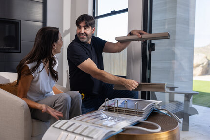 Gotcha Covered design consultant showing custom window shade samples to a homeowner during an in-home consultation